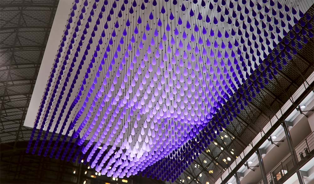 kinetic installation in the shape of a face made of many droplets