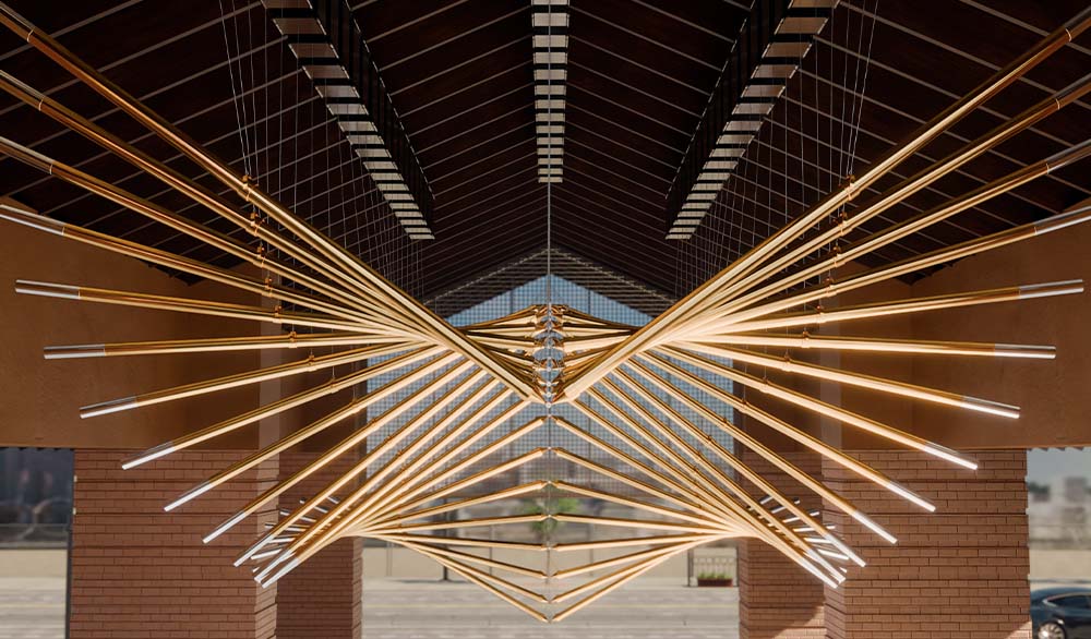 Кинетическая инсталляция "Крылья Долины" из подвесных золотых труб под крышей общественного пространства
