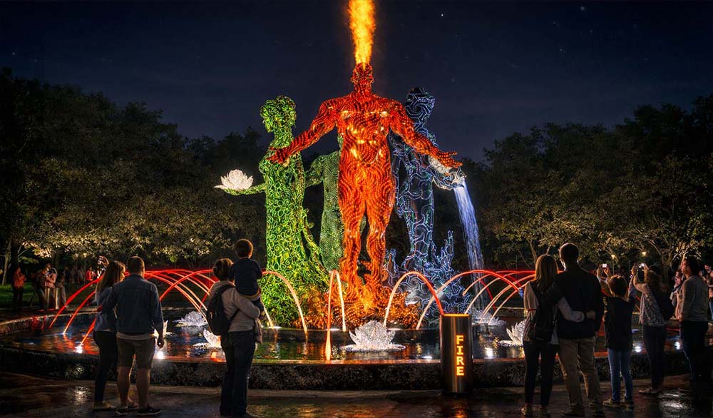 Яркий паблик арт со светящимися человеческими скульптурами, символизирующими четыре стихии — огонь, воду, воздух и землю.