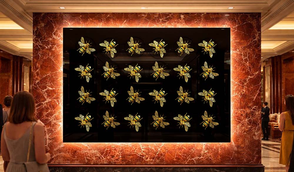 Кинетическая инсталляция «Пчелиный вальс» — композиция из 24 золотых пчёл, размещённых в ритмичной сетке на глубоком чёрном фоне, обрамлённая светящейся мраморной портальной рамой в интерьере премиального пространства.