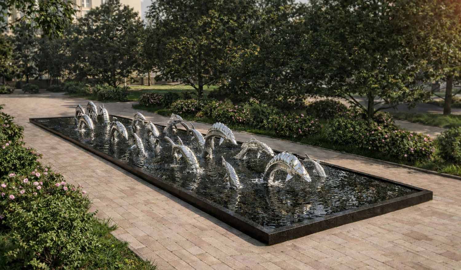 Современная скульптурная композиция «Водный мир» с выпрыгивающими из воды рыбами, гармонично встроенная в зелёный городской ландшафт.