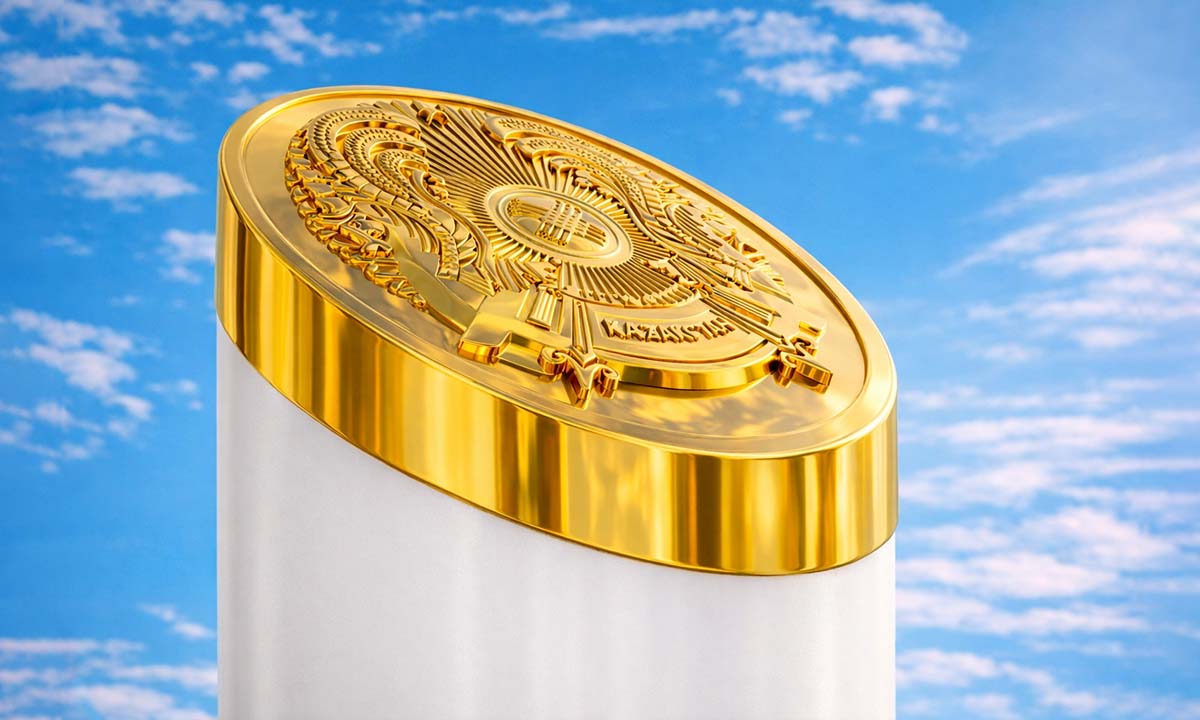 Золотистый верх интерактивной колонны с гербом Казахстана на фоне голубого неба.