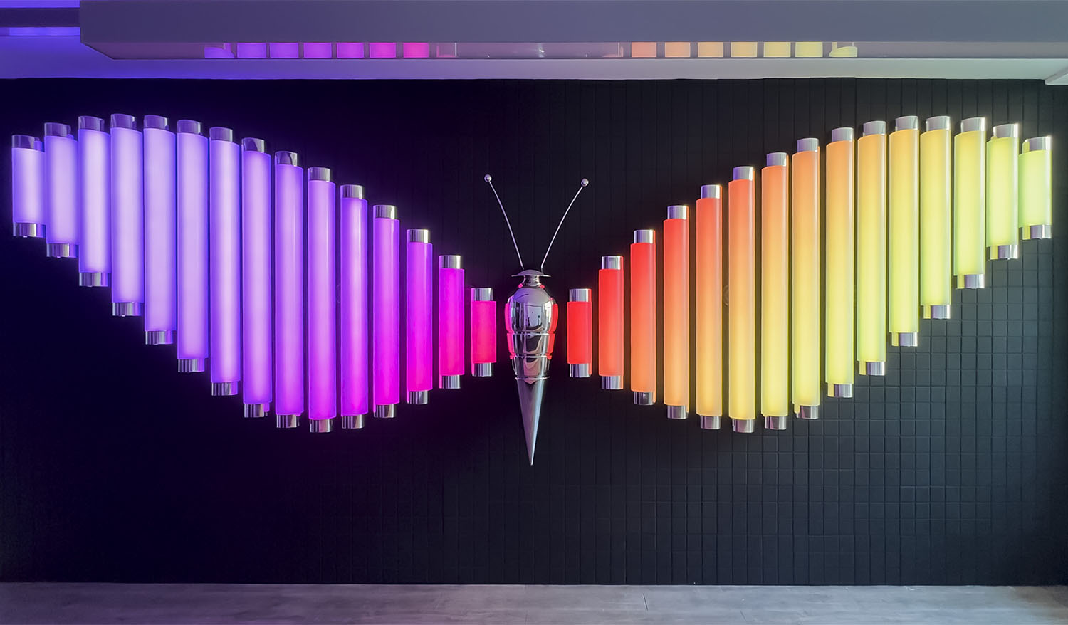 Interactive Butterfly light installation with colorful illuminated tube wings and a metallic butterfly sculpture at the center.